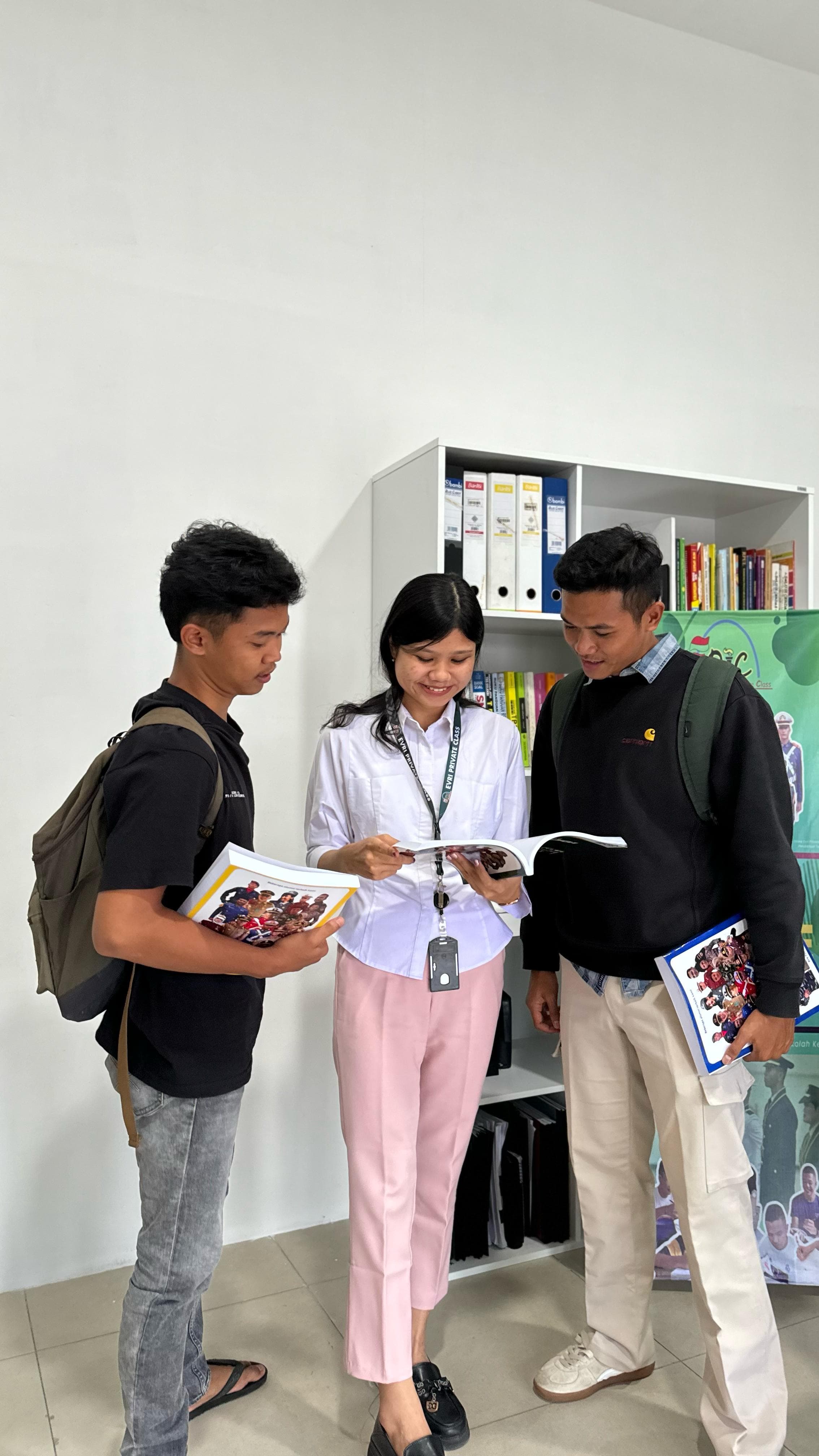 Admin membahas isi modul bersama dua calon siswa yang datang ke kantor