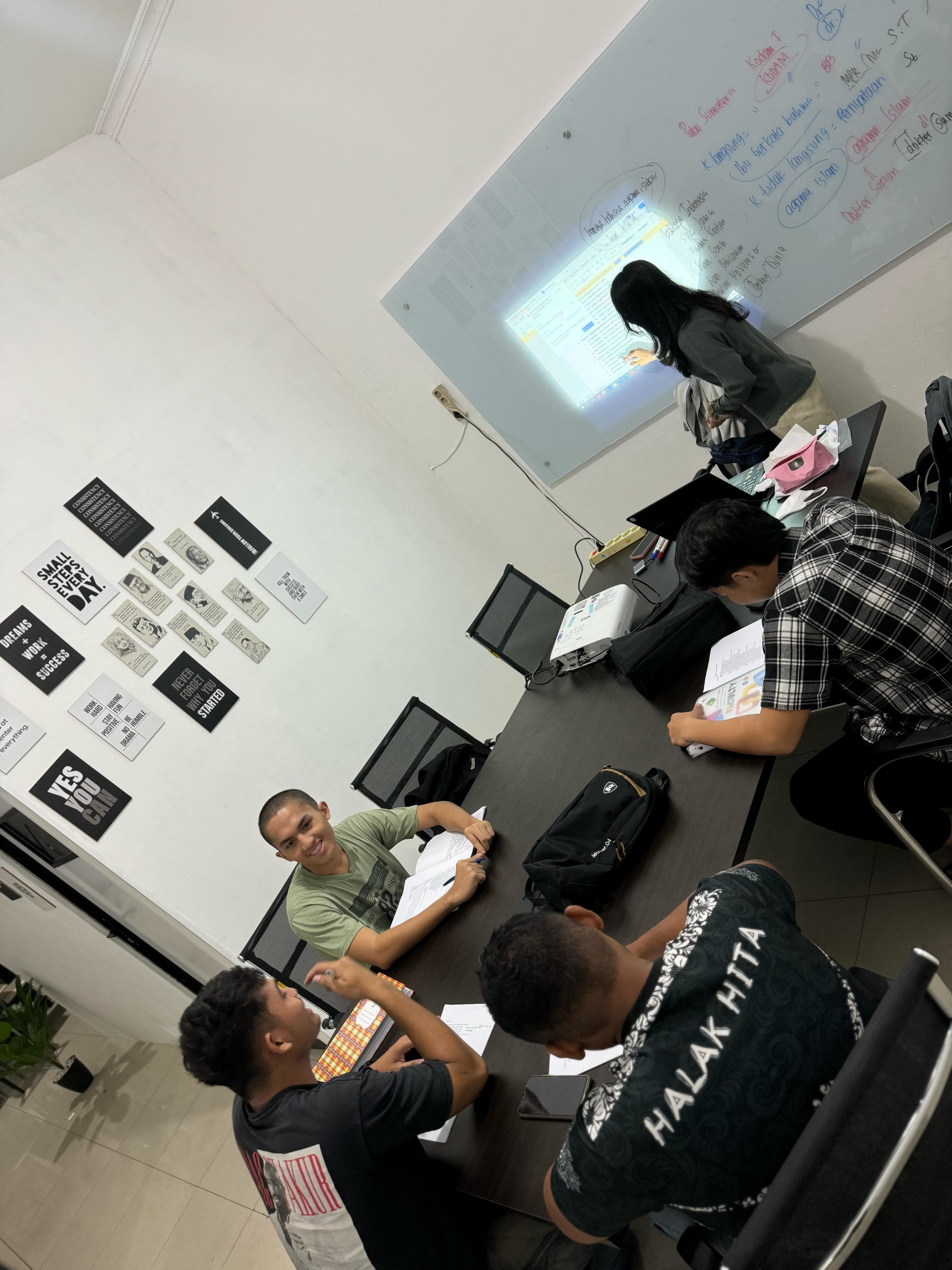 Kelas materi Tes Wawasan Kebangsaan dengan proyektor dan catatan papan tulis